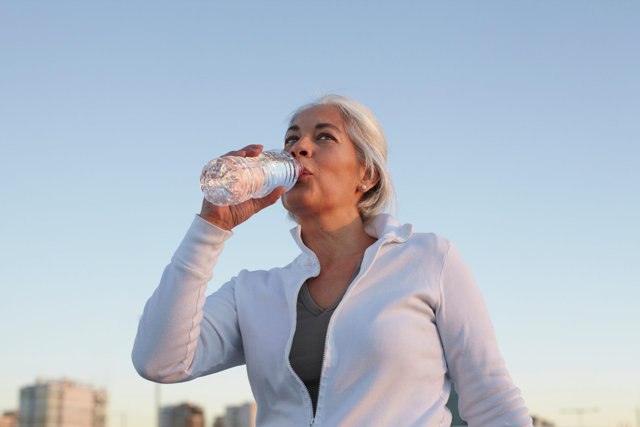 woman drinking water while exercising