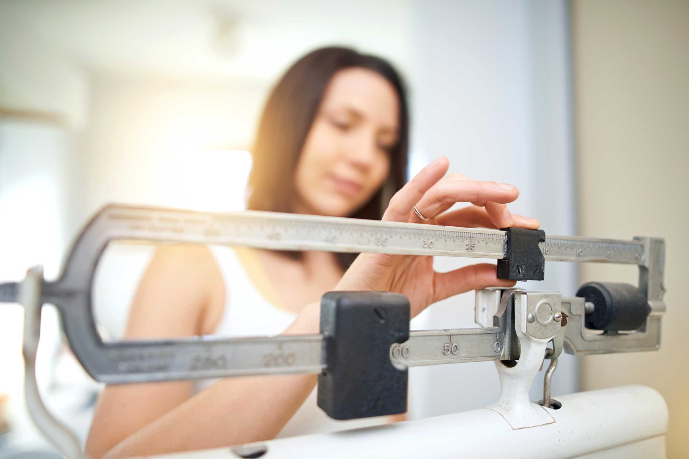 woman weighing herself on a scale