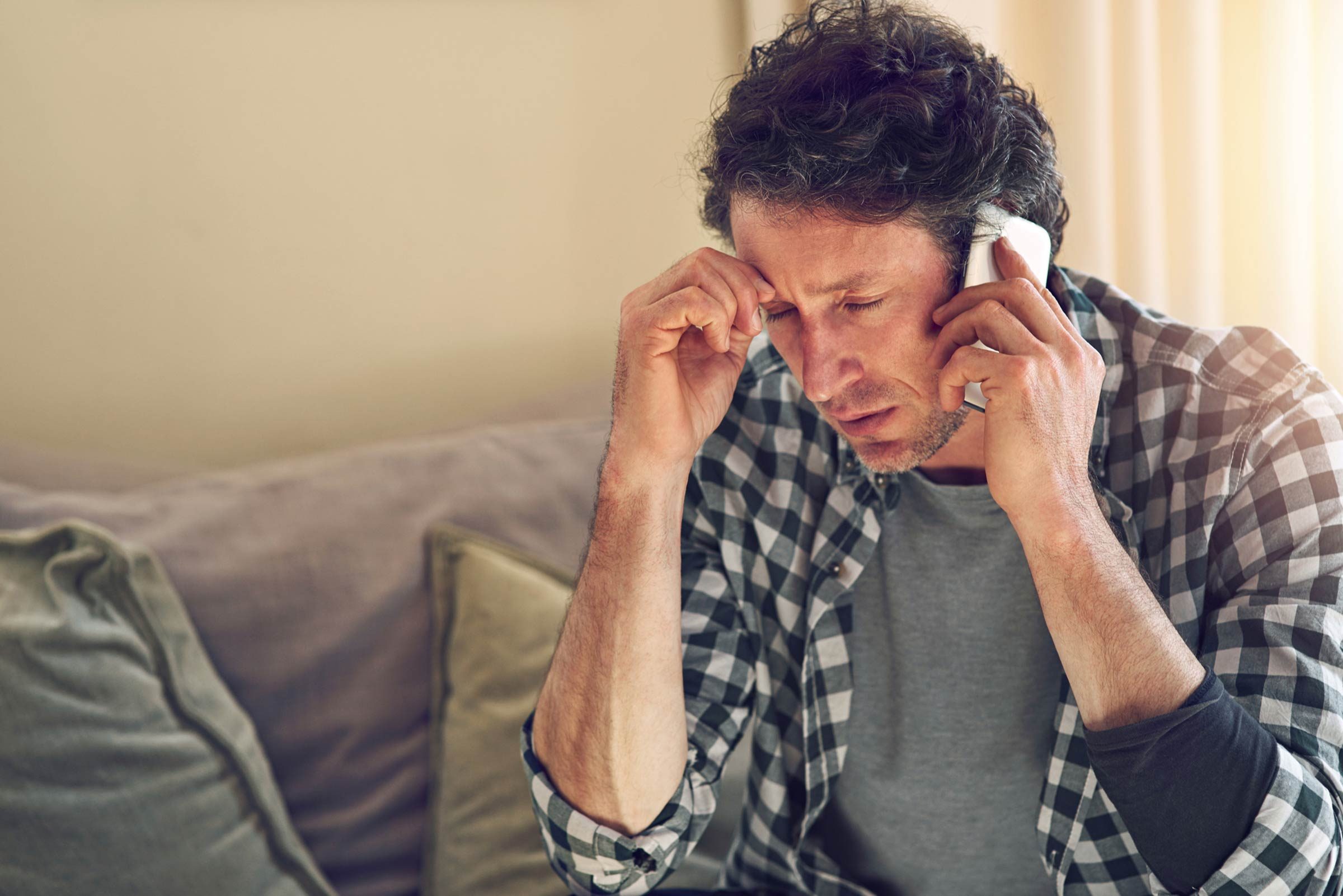 man with pained expression on phone