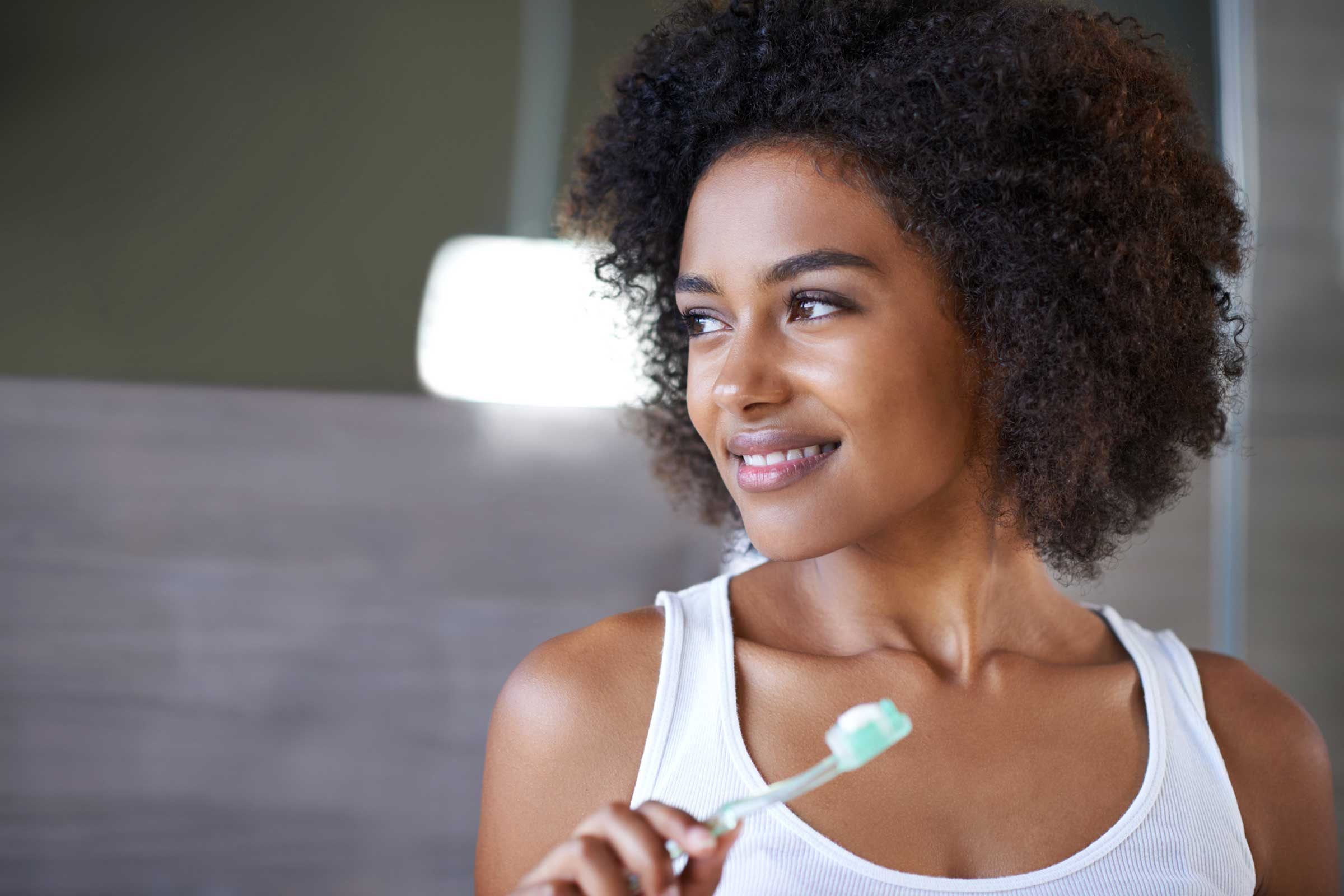 woman holding toothbrush with toothpaste on it