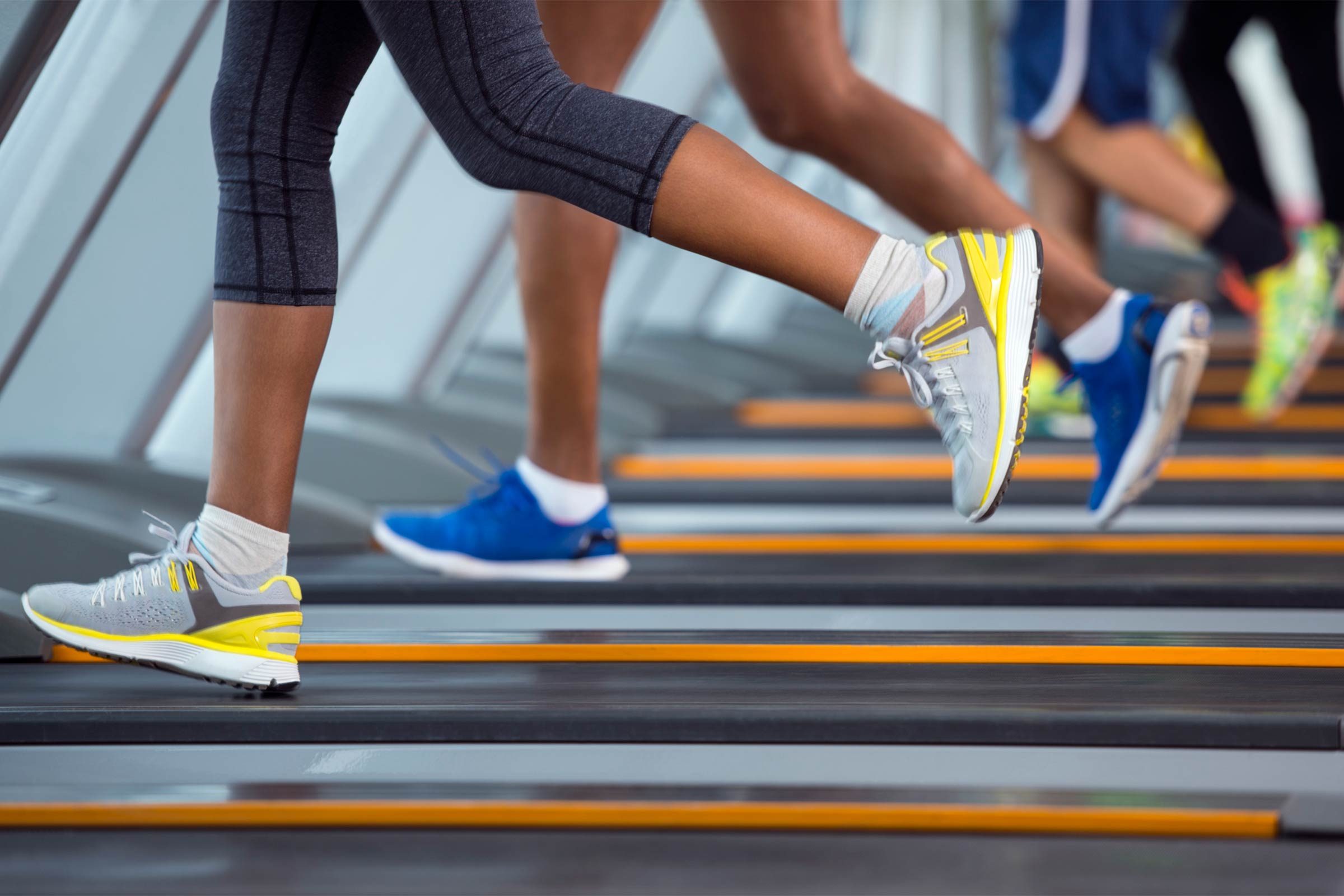 row of treadmills with people running on them