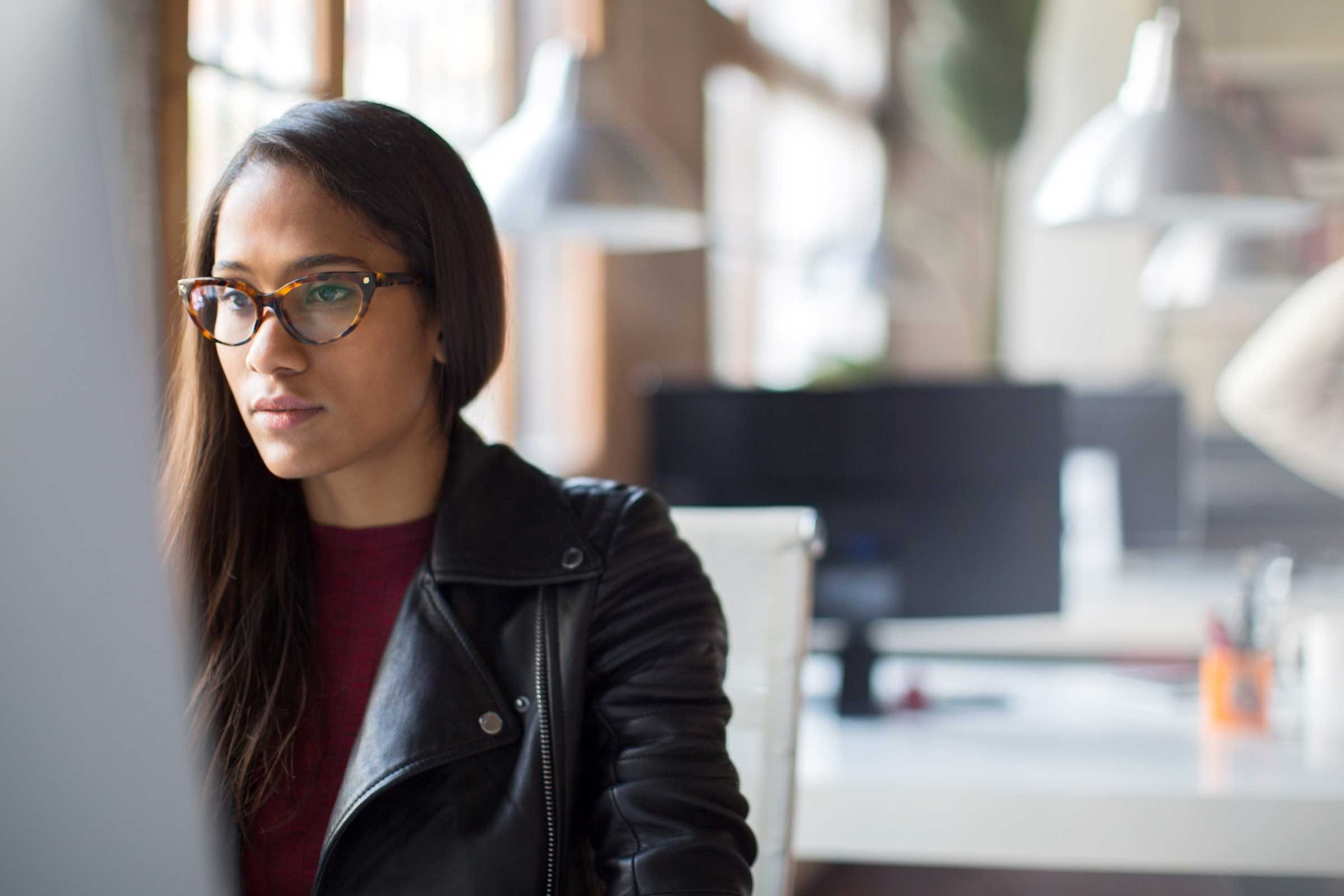 Black woman with glasses working on a computer