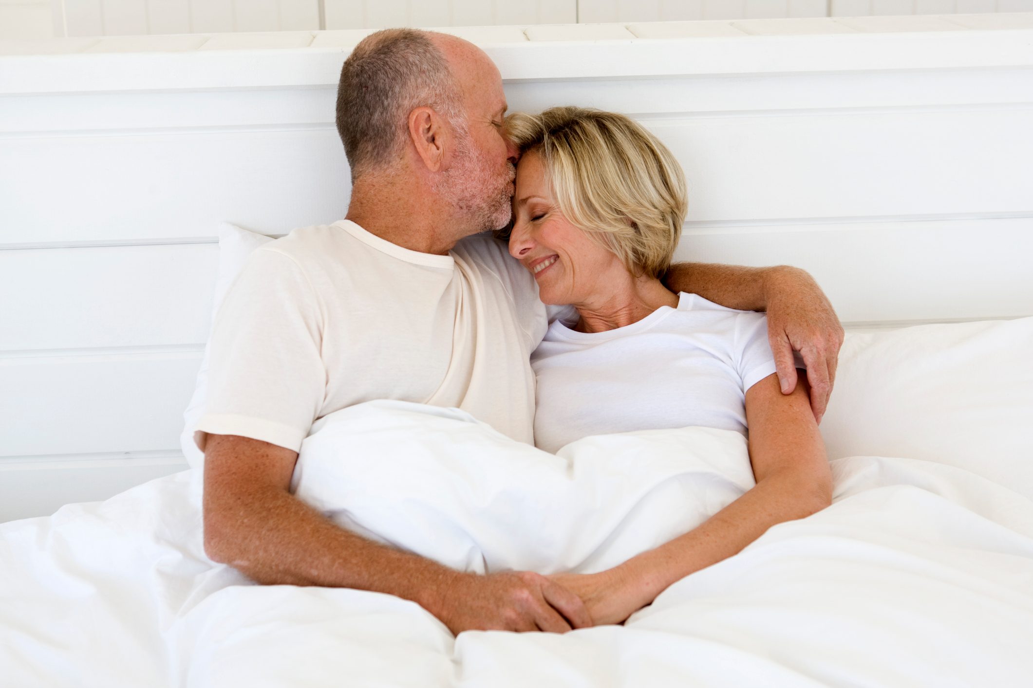 mature couple embracing in bed