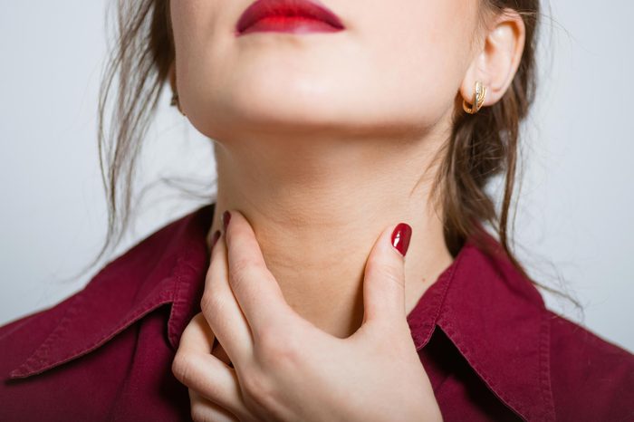 woman holding throat