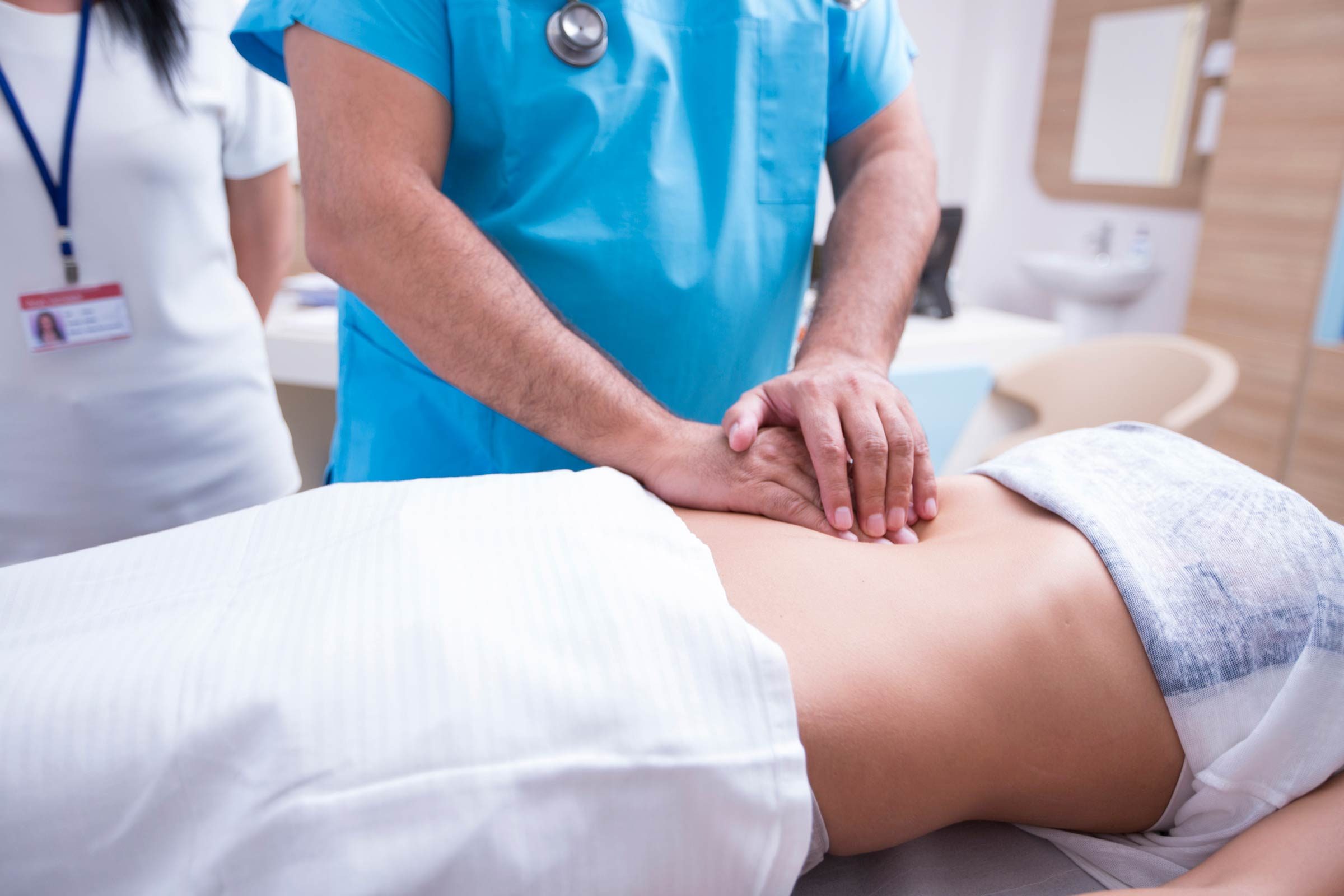 doctor checking patient's stomach