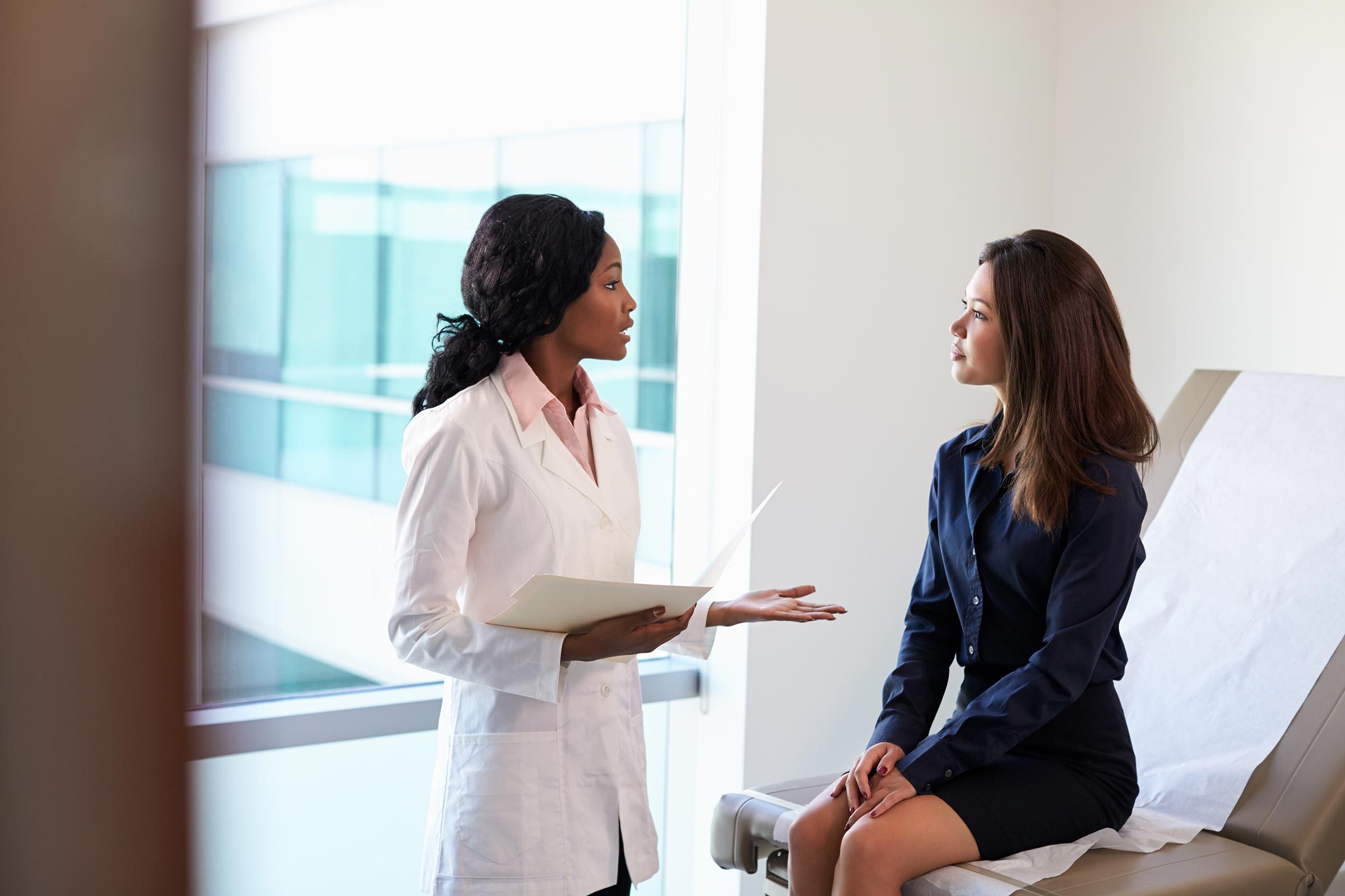 young woman doctor asian african patient