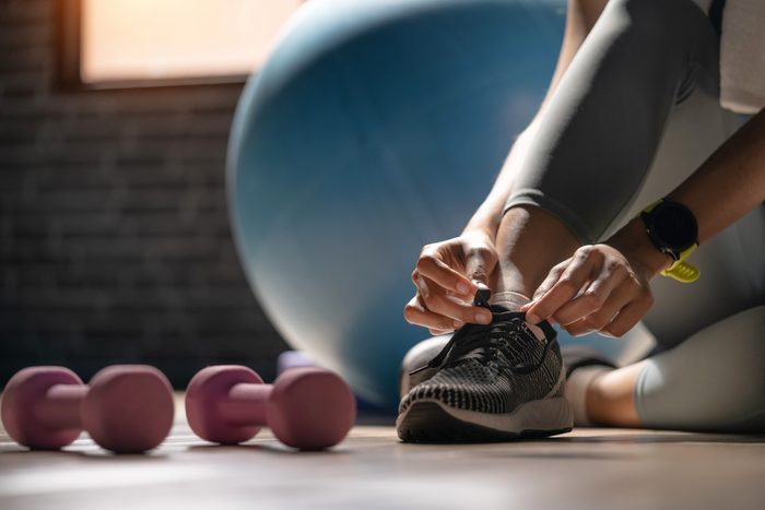 woman tying shoe laces at the gym