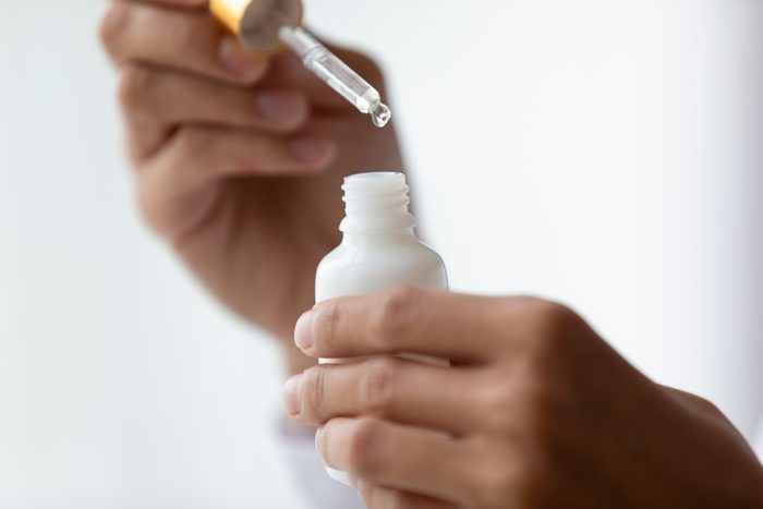woman's hands holding serum bottle
