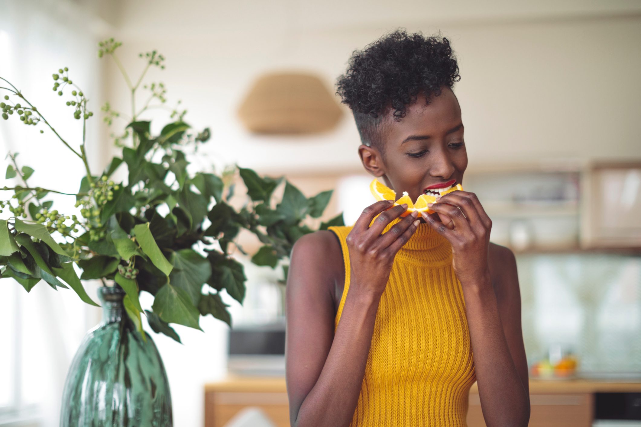 woman eating an orange at home