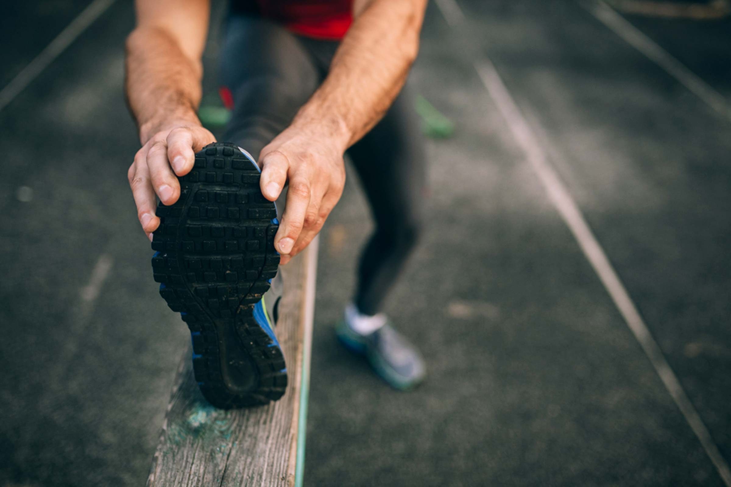 male runner stretching outside