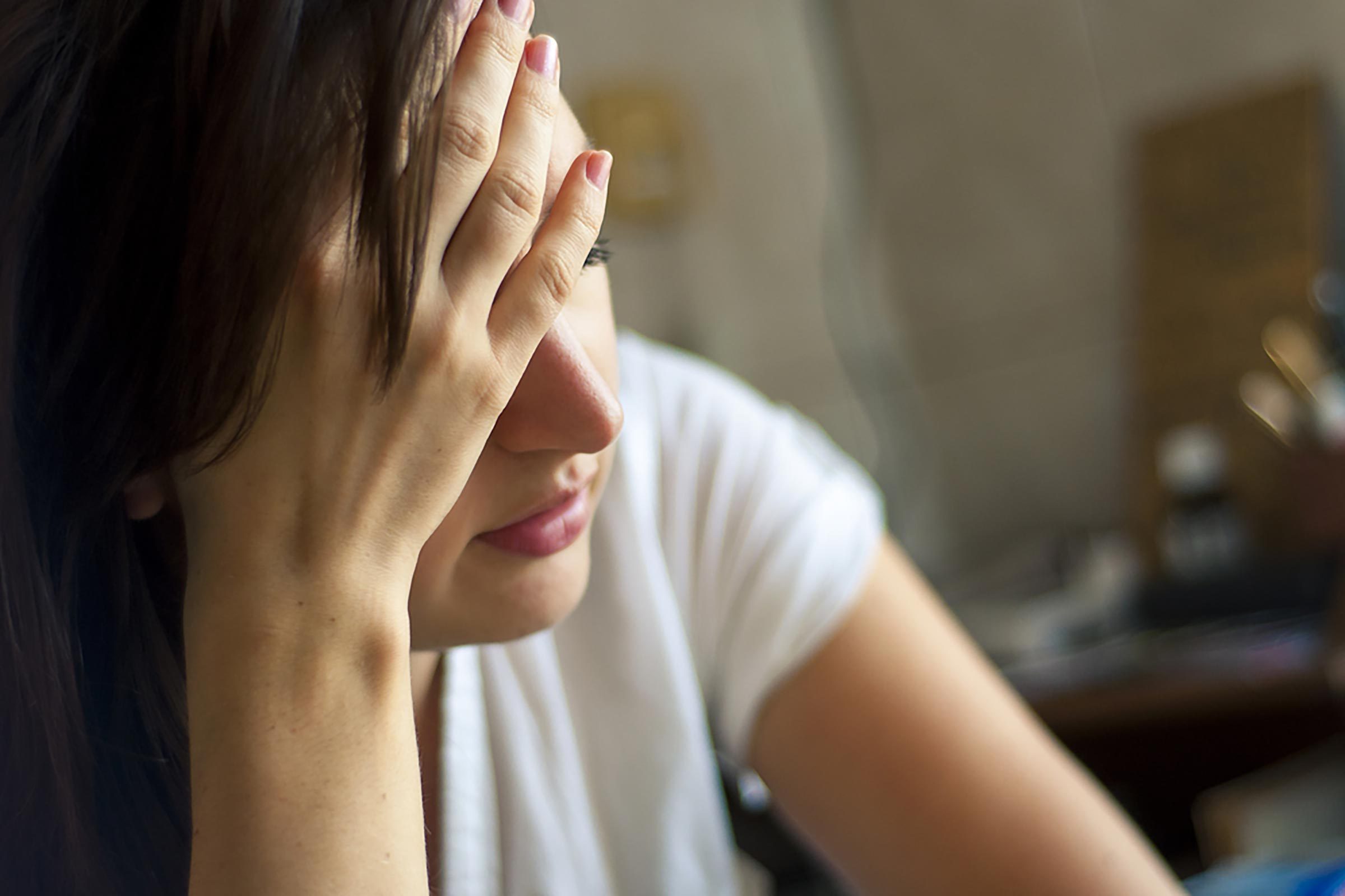 woman holding forehead looking stressed