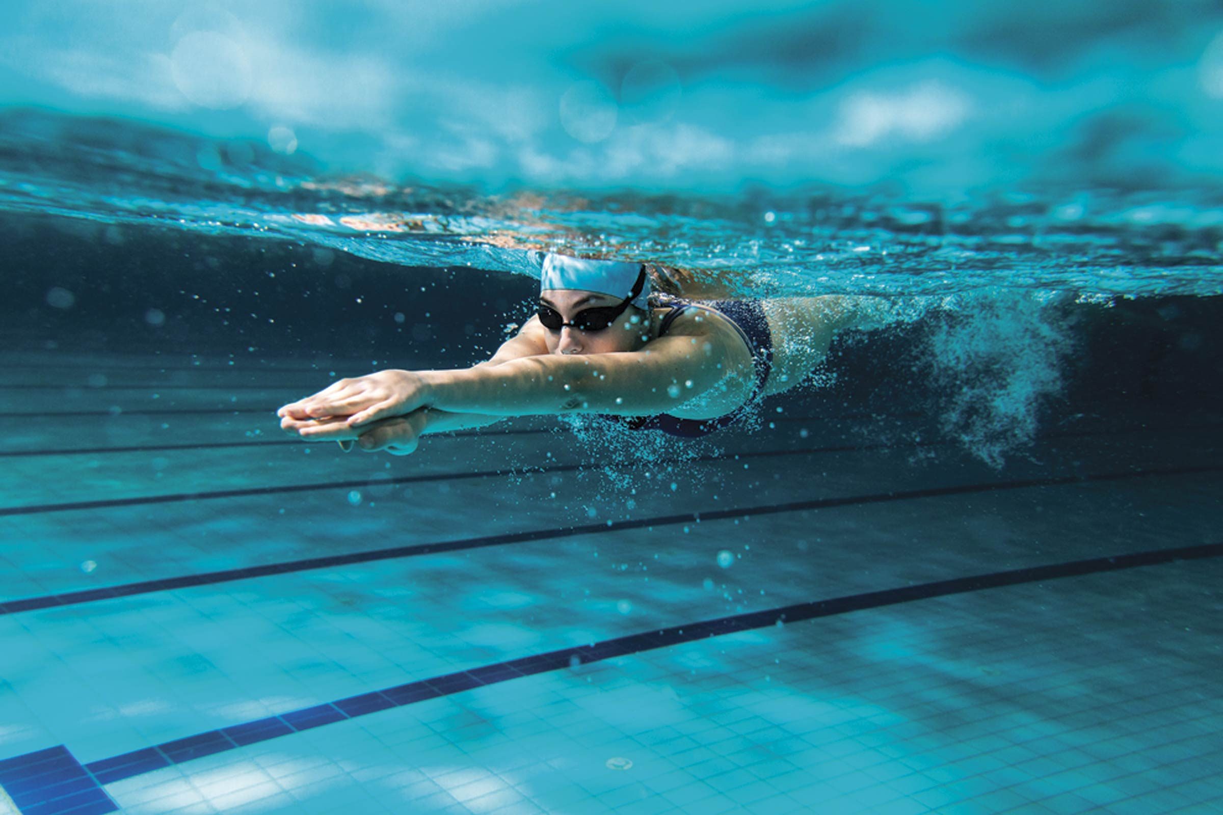 person underwater swimming in pool