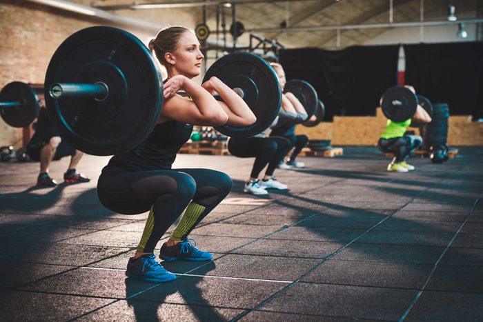Woman in gym lifting heavy weights