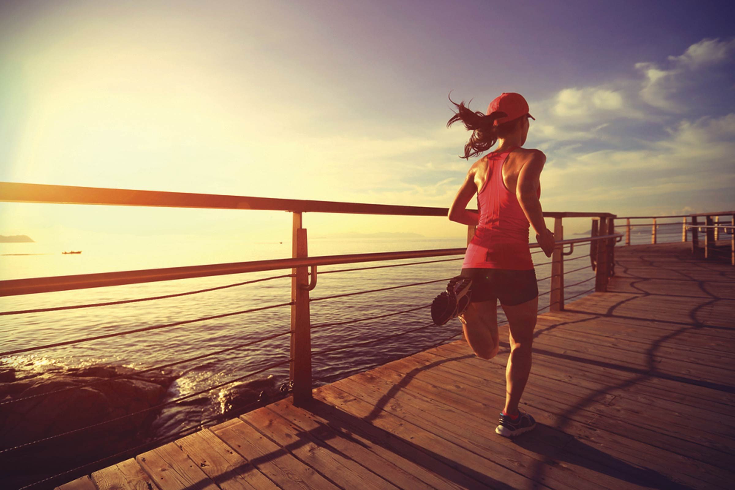 woman running with ocean in background