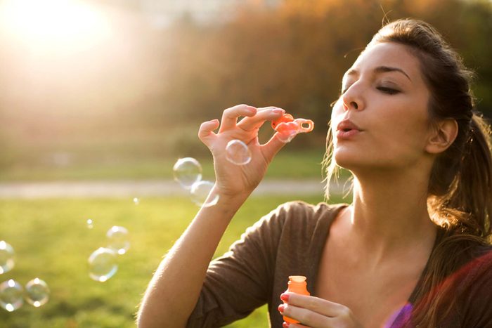 woman blowing bubbles