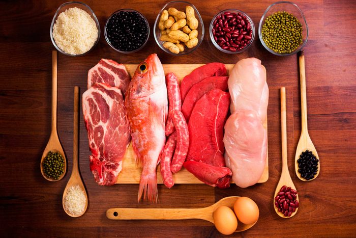 cutting board with raw fish and steaks, spices on spoons