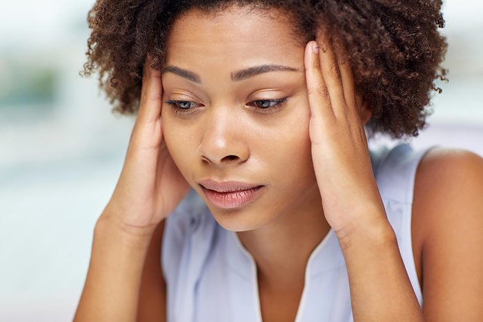 stressed woman with hands to temples
