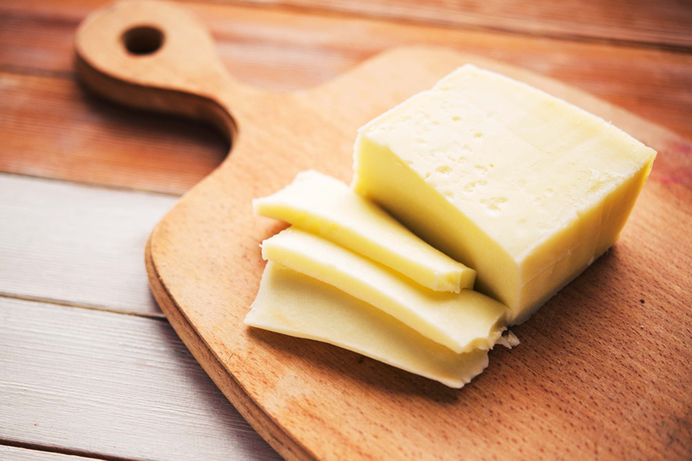 sliced cheese on wooden board