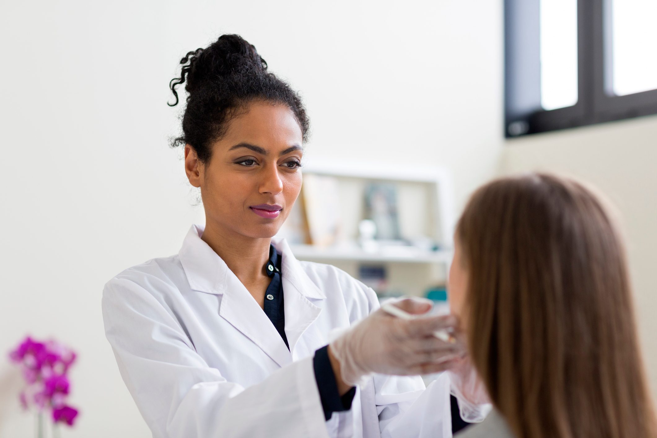 cosmetic plastic surgeon examining patient