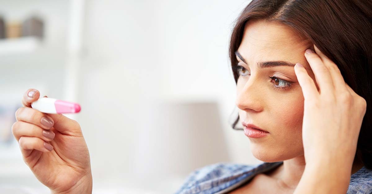 woman looking at pregnancy test
