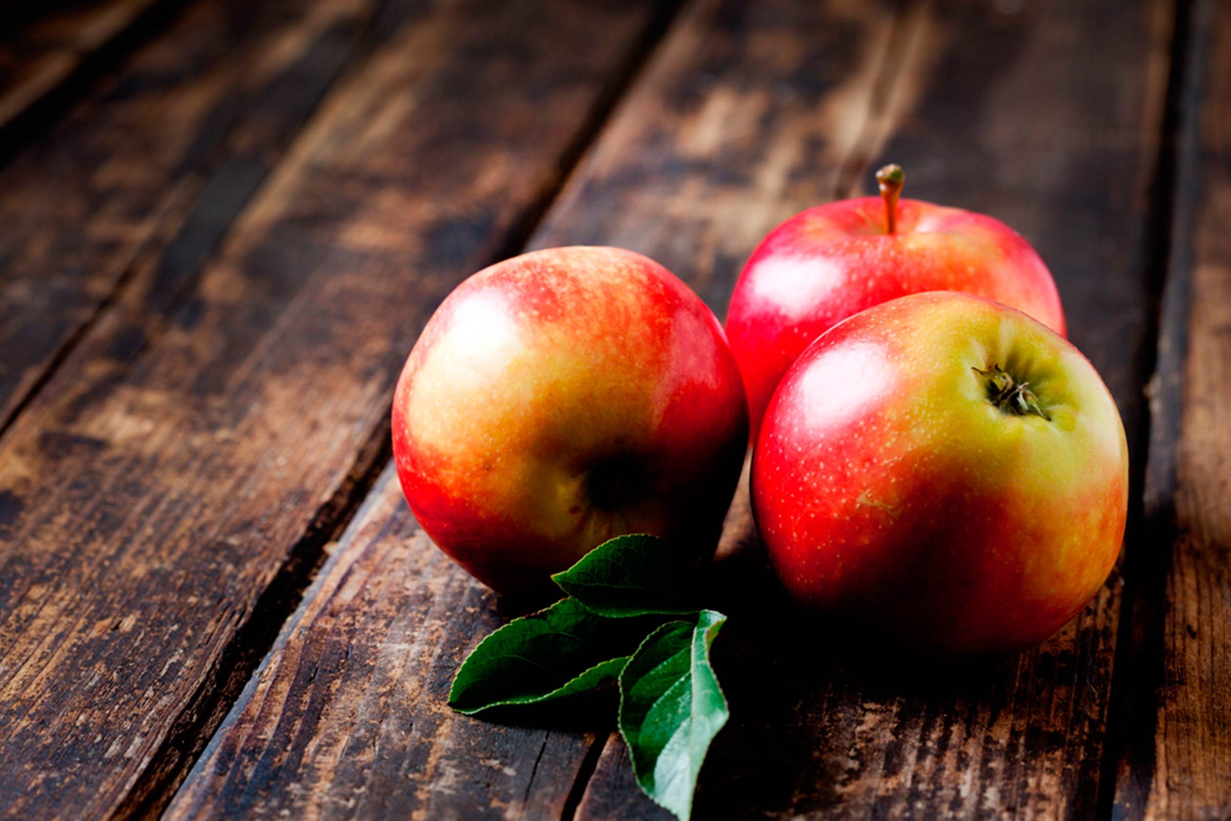 red apples on weathered wood table