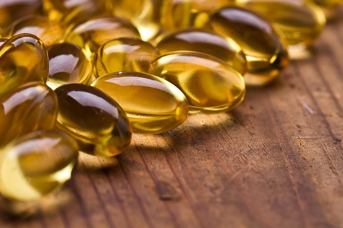 Omega 3 fatty acid capsules on a wooden surface.