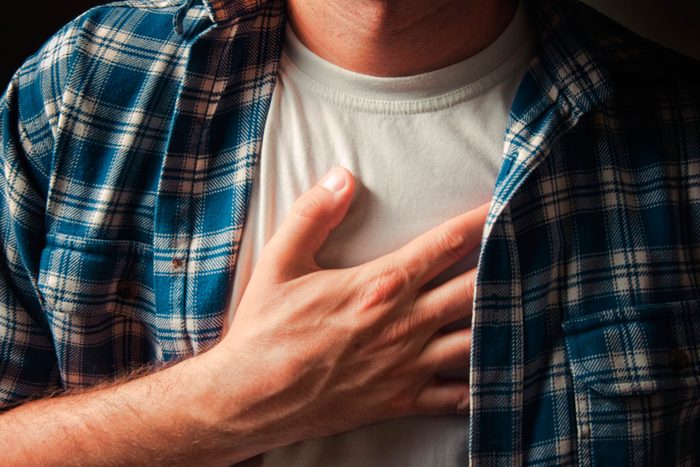 man with hand on chest
