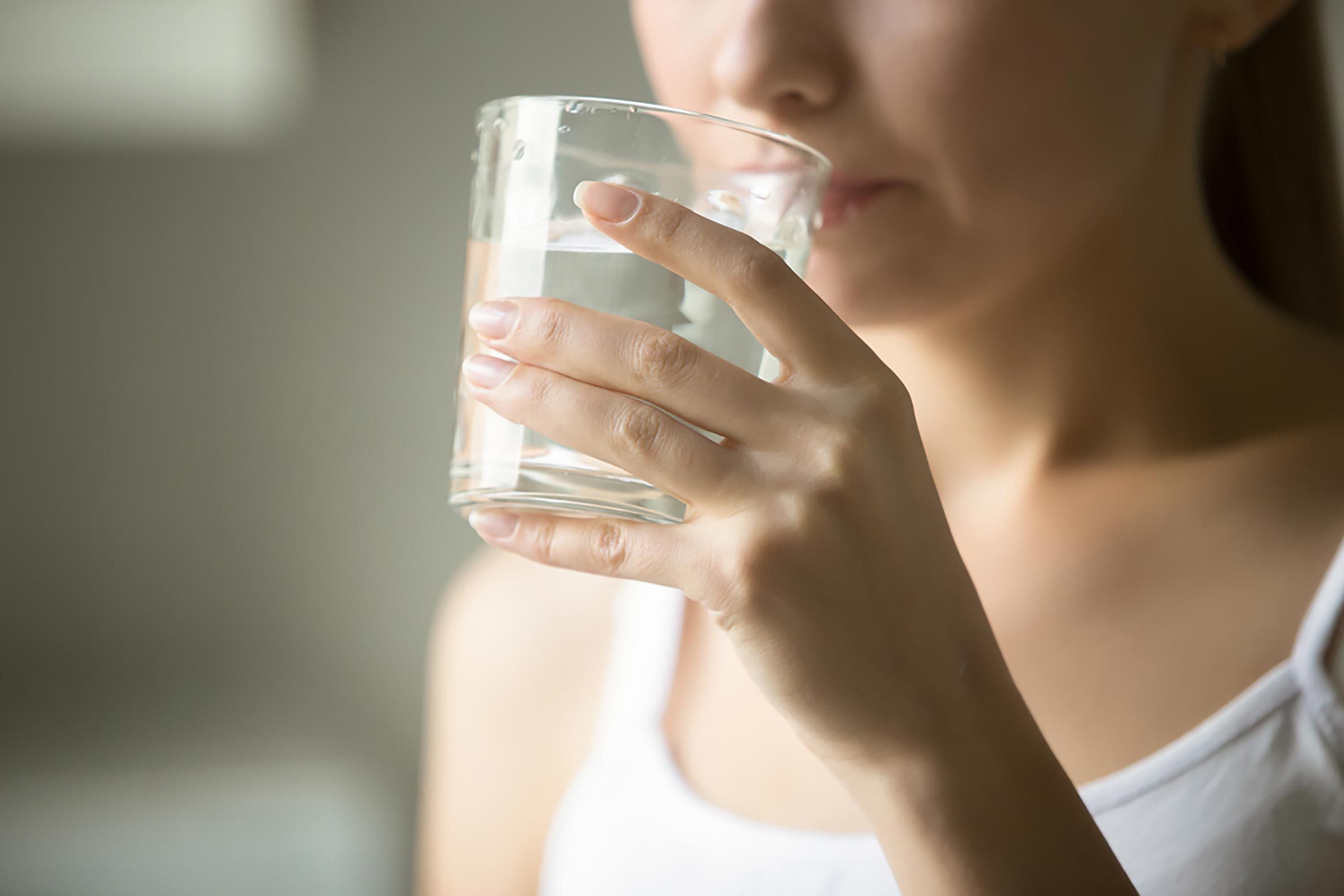 young woman sipping a glass of water