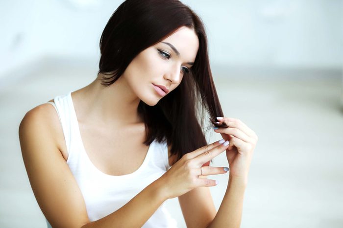 beautiful woman checking her brunette hair