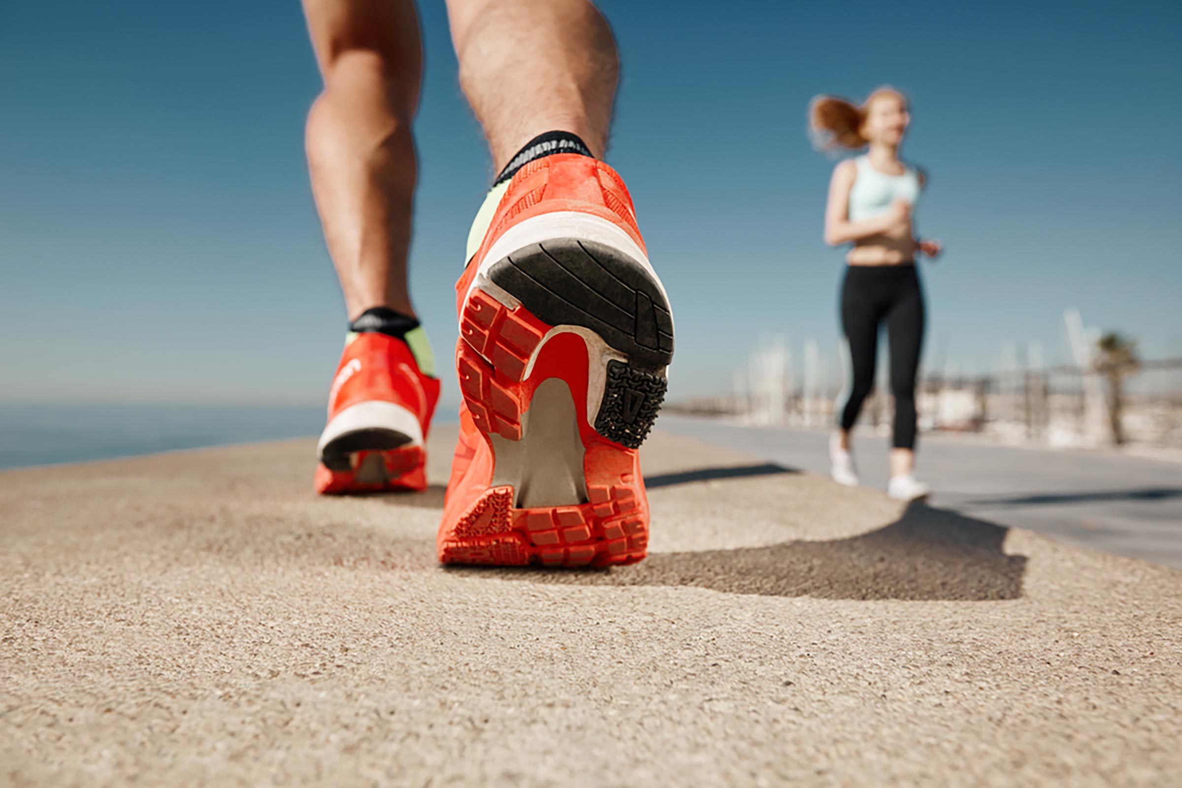 man outside in running shoes on a path