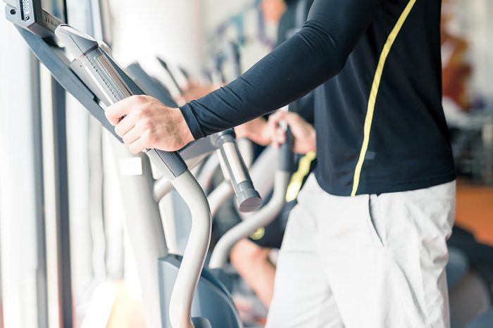 Man working out on an elliptical at the gym.