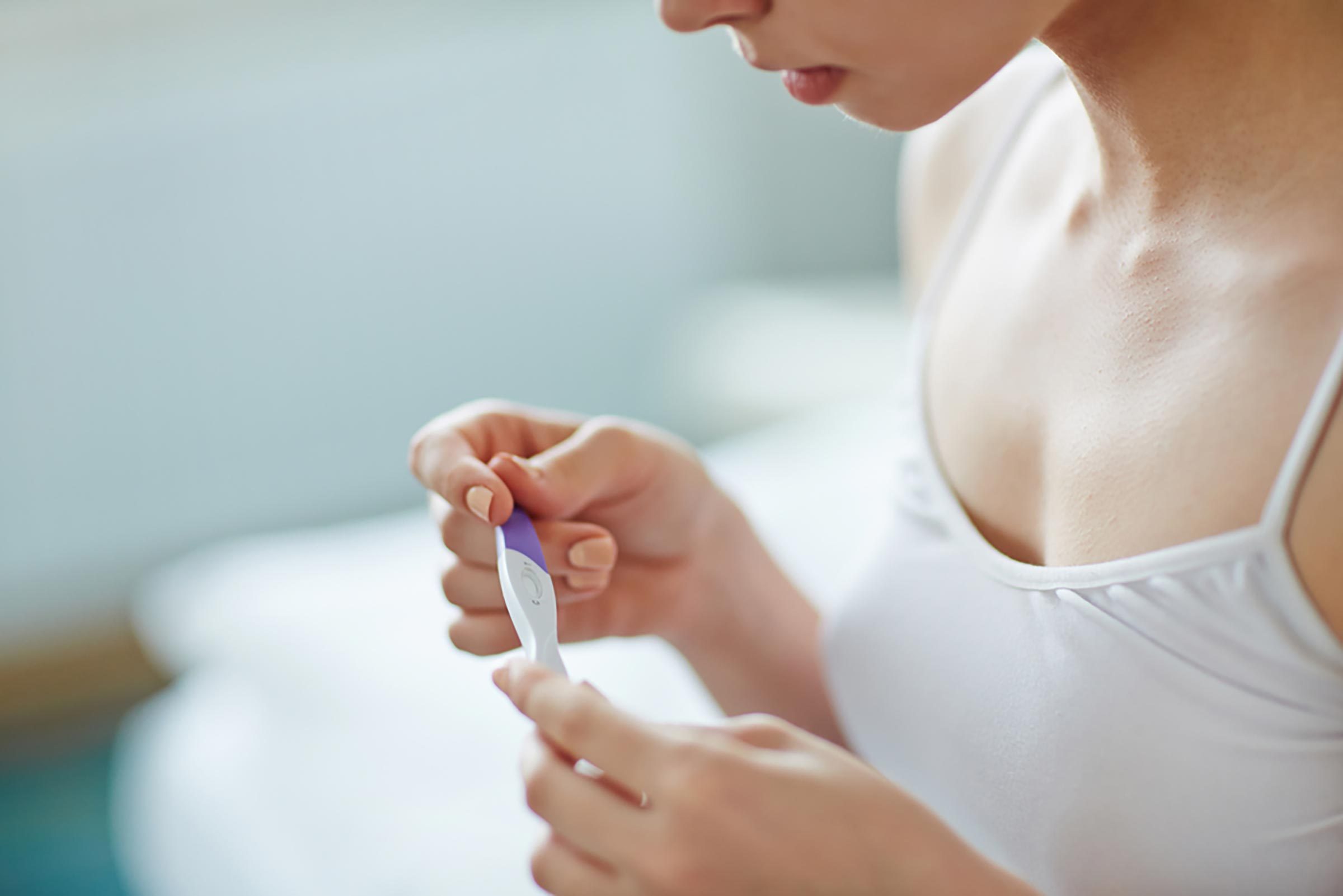 woman holding pregnancy test