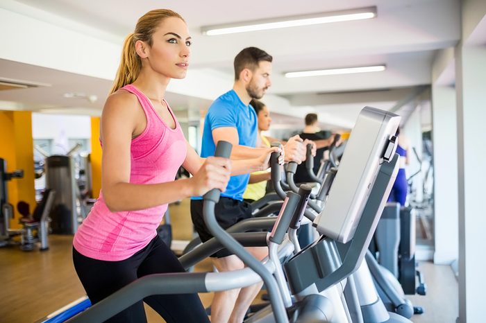 Woman working out on an elliptical at the gym.