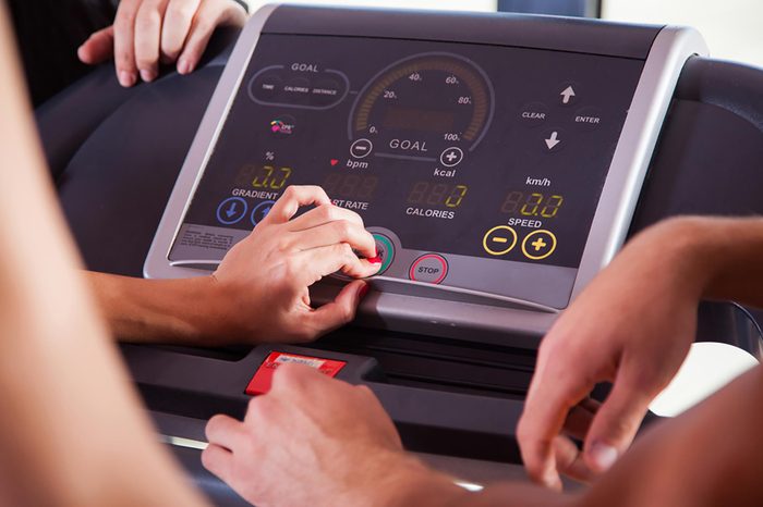 Woman adjusting a screen on the elliptical.