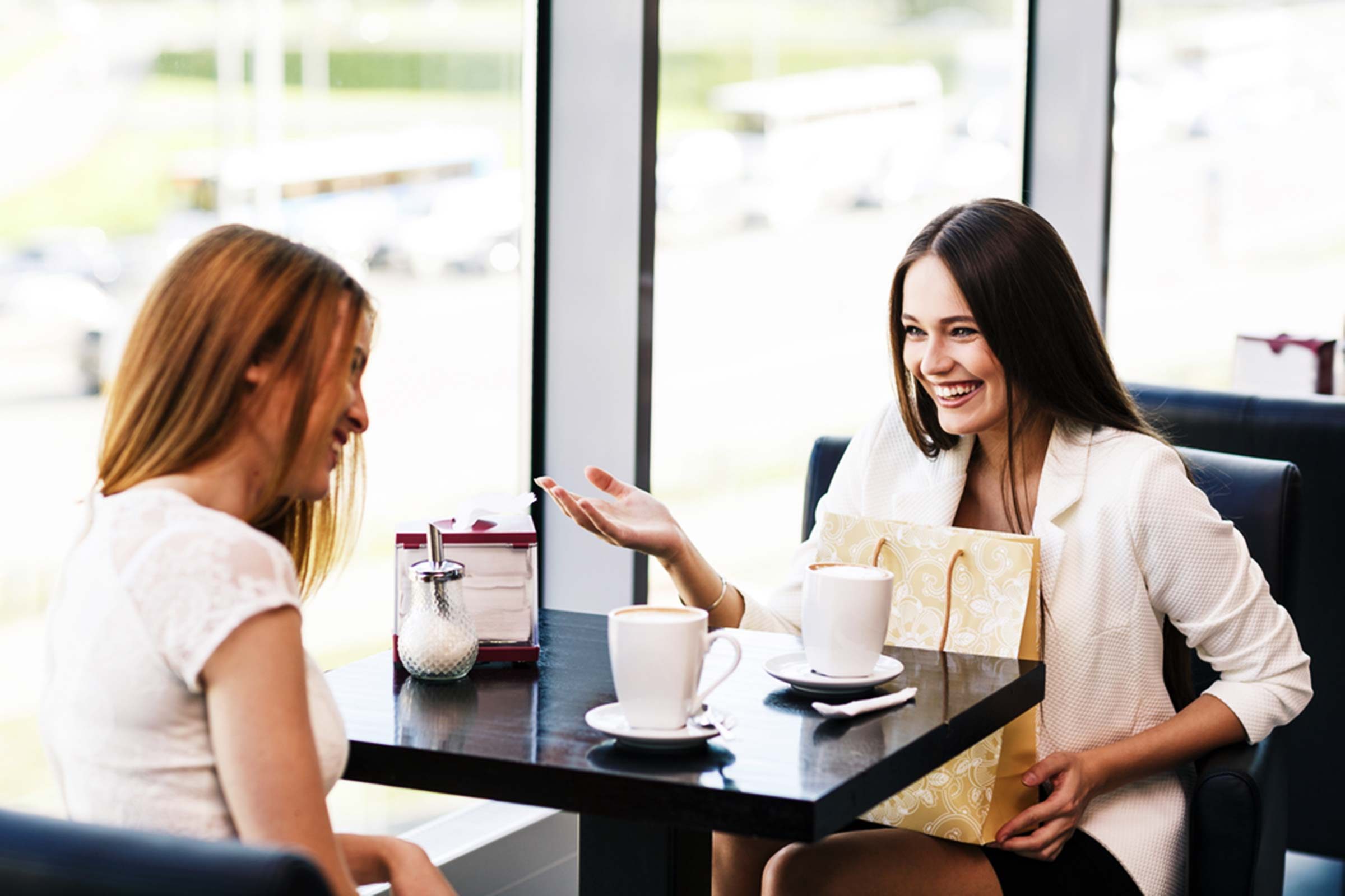 two friends catching up and smiling in a diner booth
