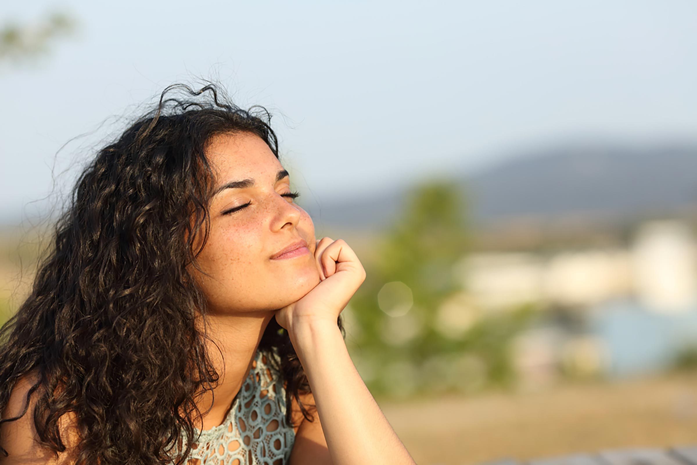 woman closes eyes in sun