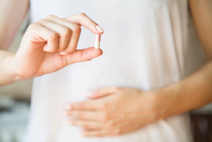 woman's hands holding capsule