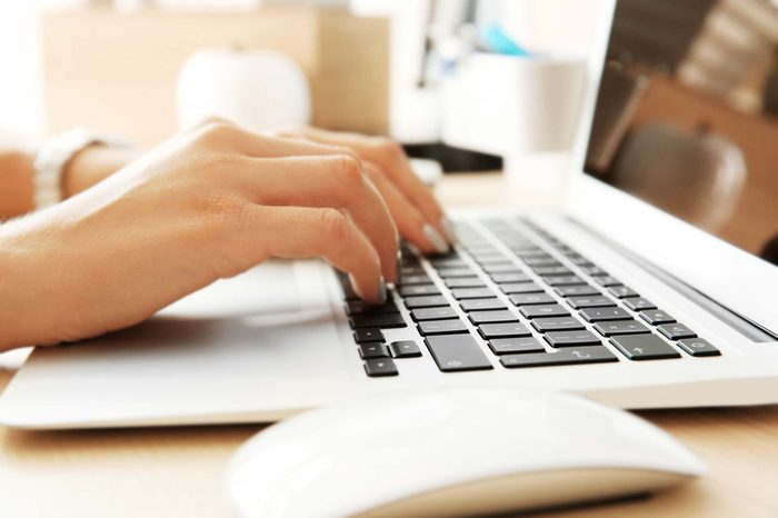 Hands on a laptop keyboard.