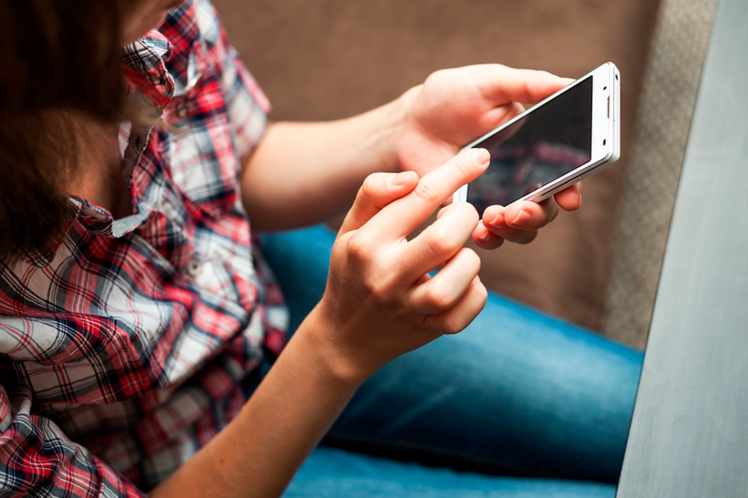 Sitting woman dialing on a smartphone