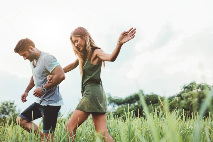 Happy couple walking in field
