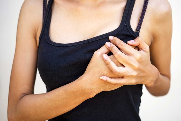 woman in black tank top holding left breast