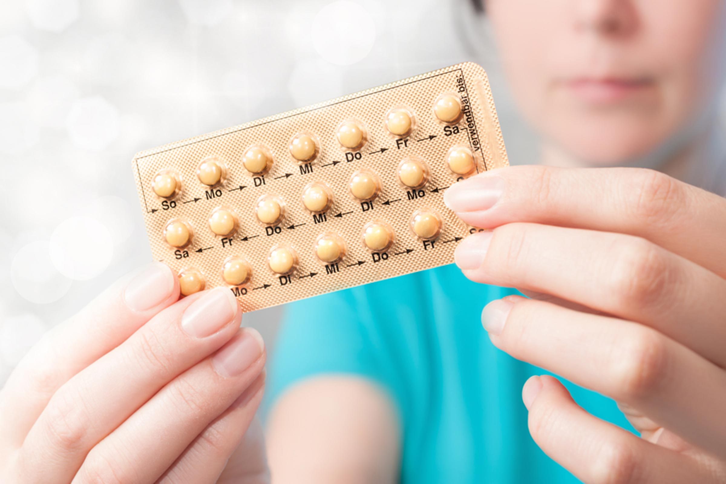 woman holding birth control pills