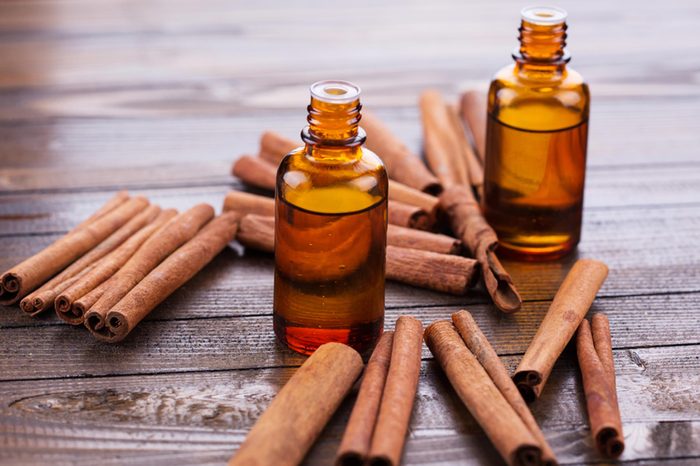 cinnamon oil and cinnamon sticks on a wooden table