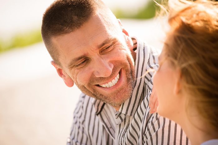 man smiling at a woman outdoors