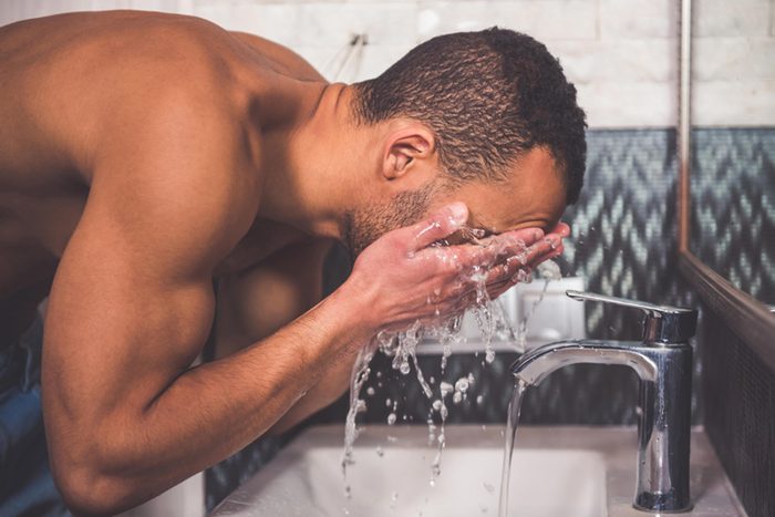 Man washing his face.