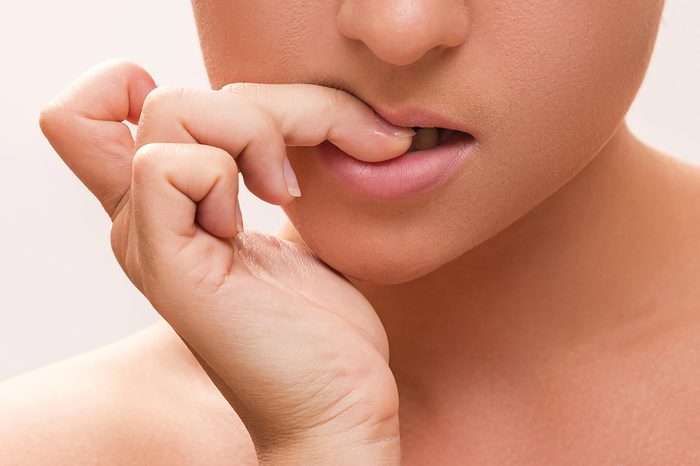 woman chewing on her nails