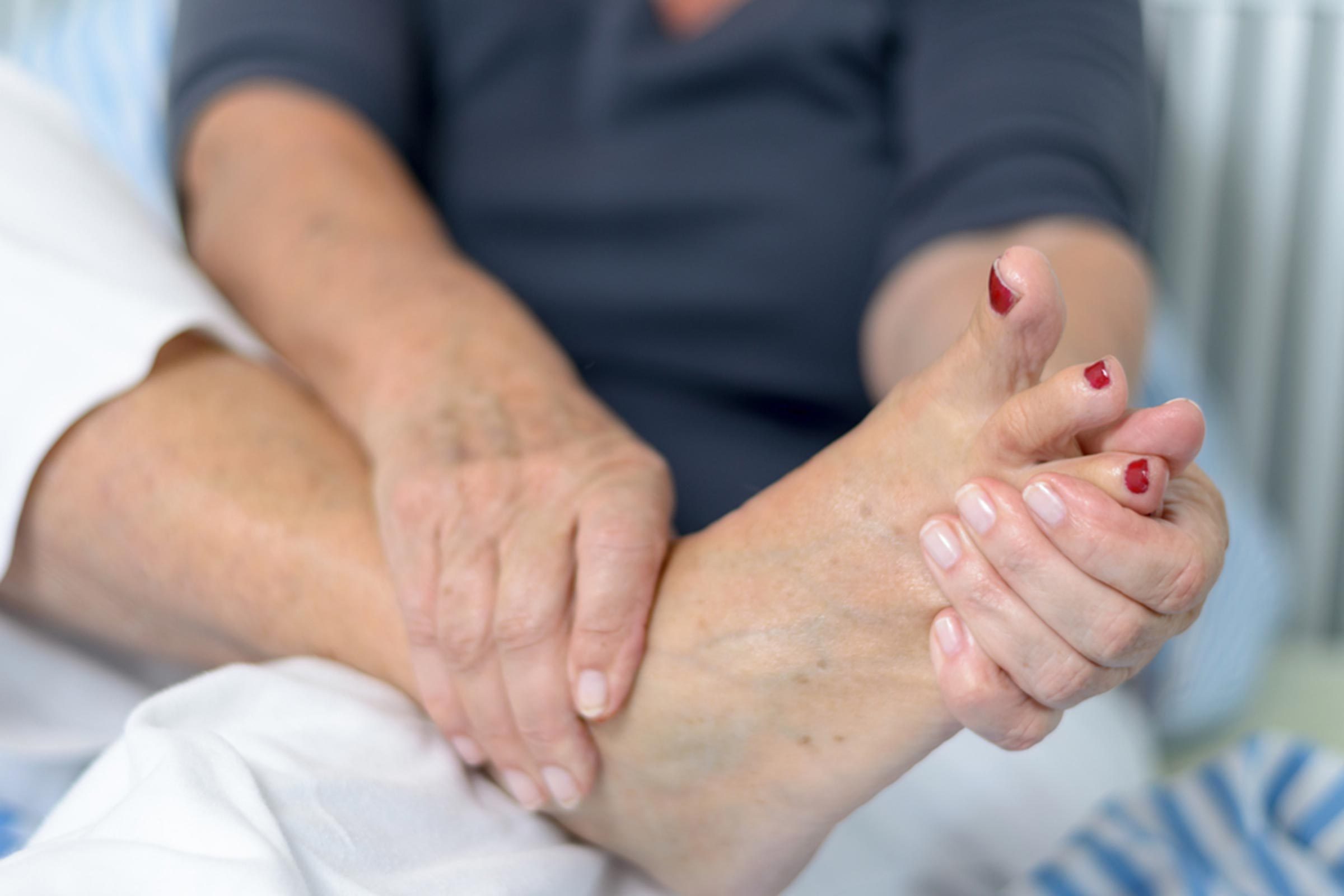 woman massaging painful foot