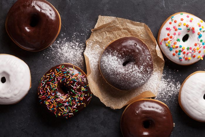 Chocolate-glazed doughnuts, some with sprinkles, on a table