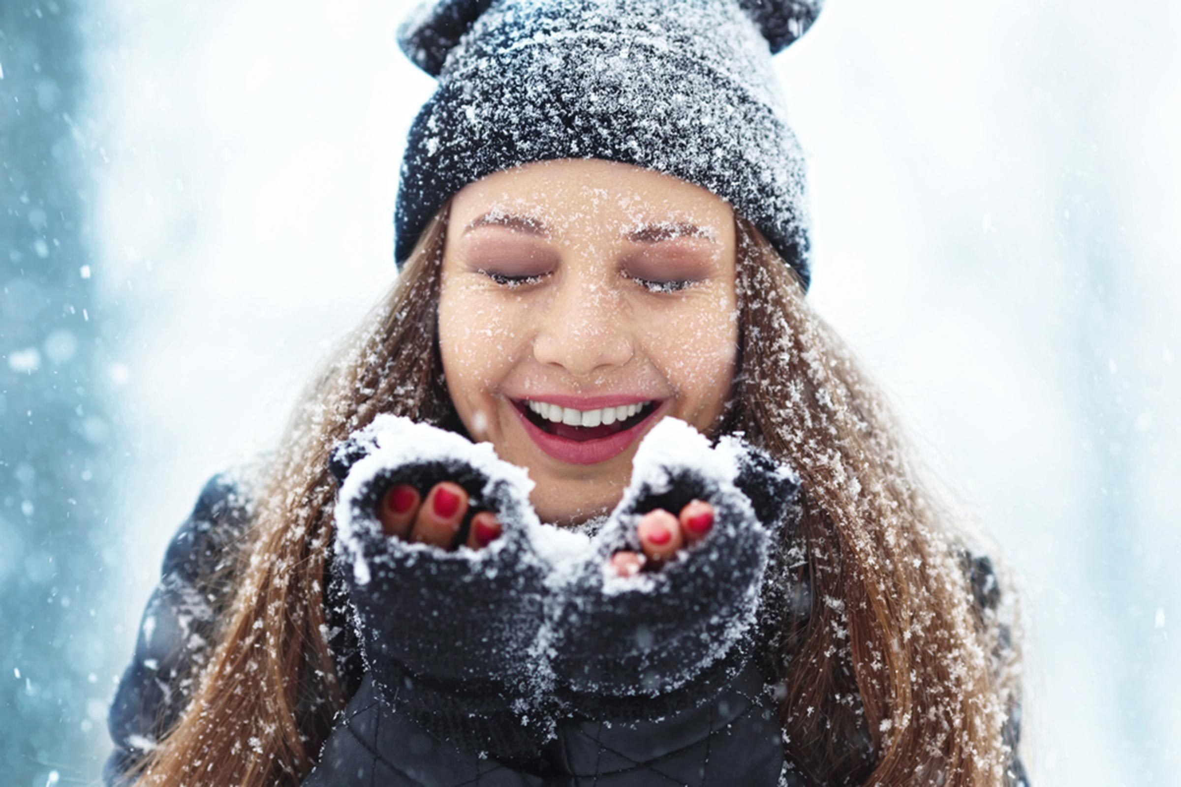 woman in winter clothes catching snow