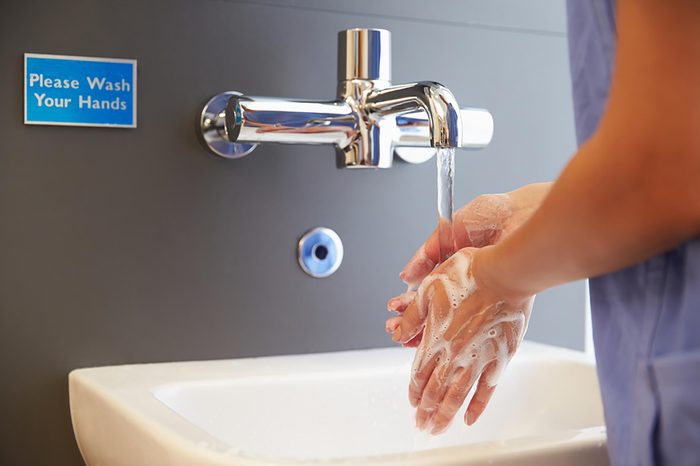 person washing their hands in the sink